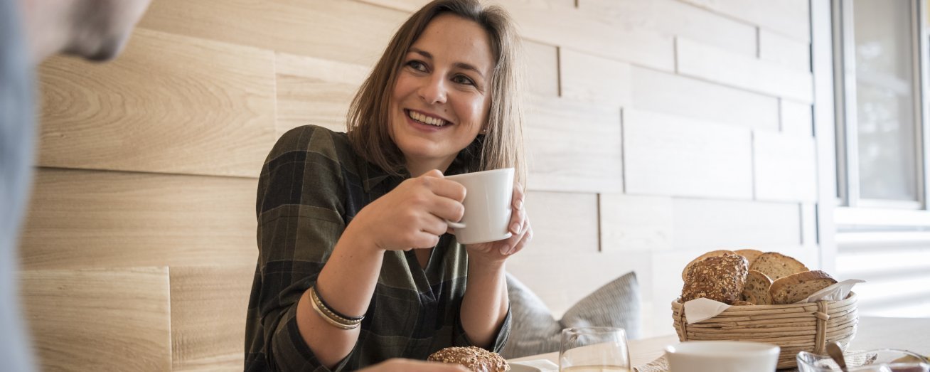 Woman with cup in hand, gluten-free bread