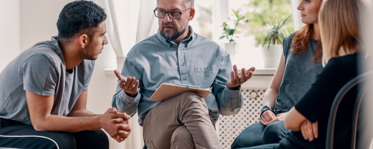 Junge Leute sitzen im Kreis, Gruppentherapie