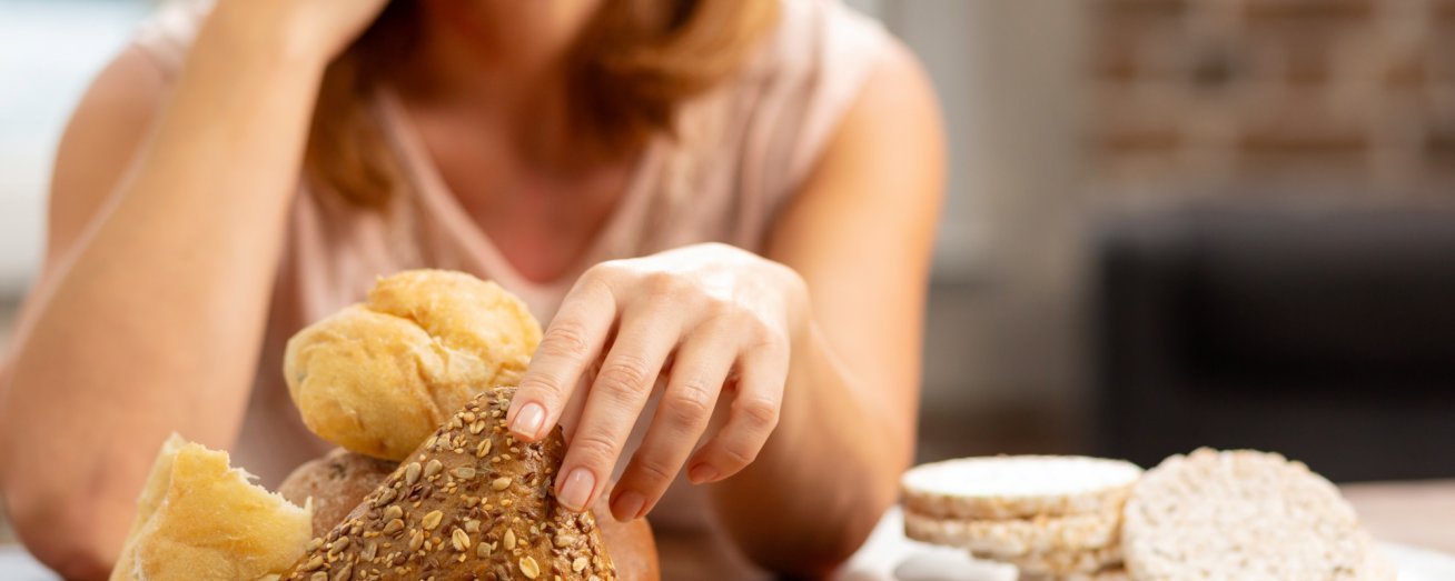 Frau sitzt vor Brot und Reiswaffeln