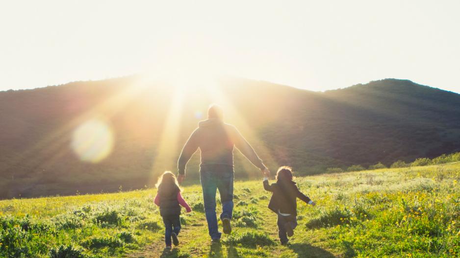 Mann mit Kindern in Sonnenuntergang